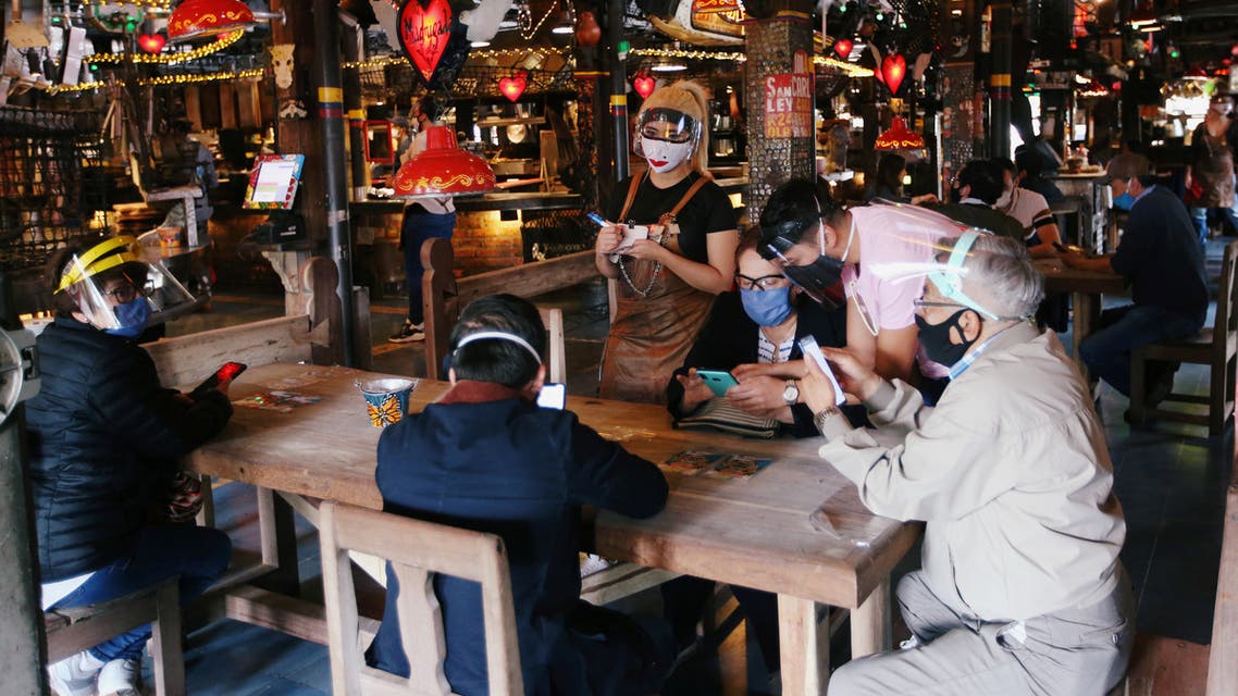 Customers wearing protective masks talk to a waiter at the Andres Carne de Res restaurant, amidst the coronavirus disease (COVID-19) outbreak, in Chia, Colombia August 30, 2020. Picture taken August 30, 2020. REUTERS/Luisa Gonzalez