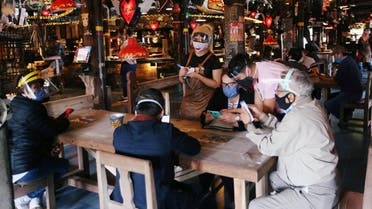 Customers wearing protective masks talk to a waiter at the Andres Carne de Res restaurant, amidst the coronavirus disease (COVID-19) outbreak, in Chia, Colombia August 30, 2020. Picture taken August 30, 2020. REUTERS/Luisa Gonzalez