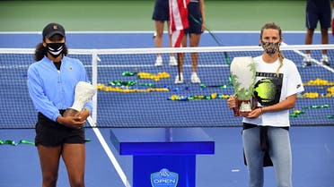 Naomi Osaka with her 2nd place trophy on the court during the awards ceremony for singles champion Victoria Azarenka, right, in the Western & Southern Open in New York, on August 29, 2020. Osaka withdrew from the final due to a left hamstring injury. (Reuters)