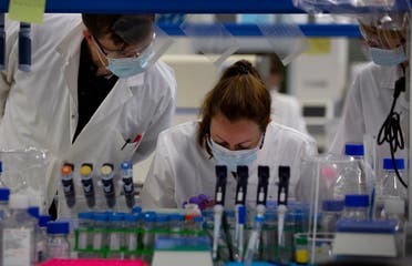 Lab technicians speak with each other during research on coronavirus, COVID-19, at Johnson & Johnson subsidiary Janssen Pharmaceutical in Beerse, Belgium. (AP)