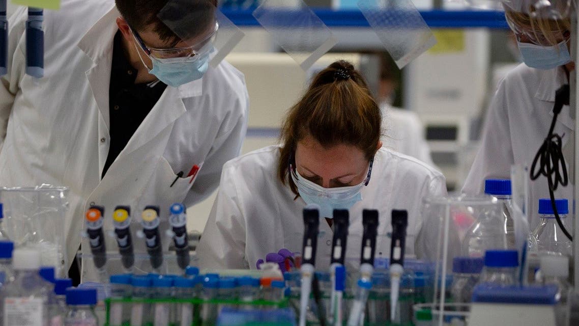Lab technicians speak with each other during research on coronavirus, COVID-19, at Johnson & Johnson subsidiary Janssen Pharmaceutical in Beerse, Belgium. (AP)