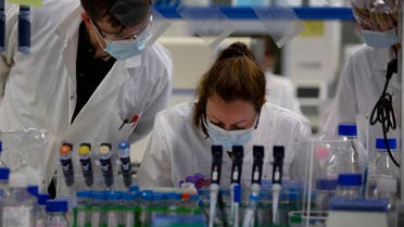 Lab technicians speak with each other during research on coronavirus, COVID-19, at Johnson & Johnson subsidiary Janssen Pharmaceutical in Beerse, Belgium. (AP)