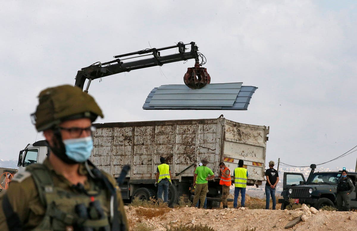 Israeli soldiers and border police gather as a structure serving as a home to a Palestinian family is demolished in the village of Susya south Yatta in the southern West Bank. (File photo: AFP)