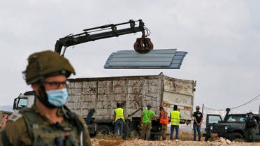 Israeli soldiers and border police gather as a structure serving as a home to a Palestinian family is demolished in the village of Susya south Yatta in the southern West Bank. (AFP)