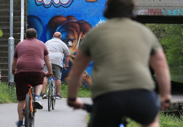 رجال يعانون من البدانة يماسرون ركوب الدراجات خلال الإغلاق في مايو الماضي في انكلترا