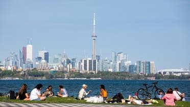 People maintain social distance as they sit at Humber Bay Shores park, Ontario, Canada May 24, 2020. (Reuters)