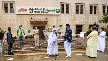 Men arriving at the police station of Naif locality queue before they are allowed to enter due to a limit on the number of persons permitted inside buildings amidst efforts to counter the COVID-19 coronavirus pandemic, in the Gulf emirate of Dubai on April 15, 2020. (AFP)