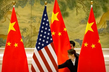 Chinese staff adjust US and Chinese flags before the opening session of trade negotiations between US and Chinese trade representatives at the Diaoyutai State Guesthouse in Beijing on February 14, 2019. (AFP)
