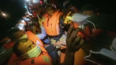 Dozens of migrants, from Egypt, Morocco, Somalia and Sierra Leone, are assisted by a team of aid workers of the Spanish NGO Open Arms, after spending more than 20 hours at sea while fleeing Libya on board a precarious boat in international waters, in the Central Mediterranean sea, on September 08, 2020. (AFP)