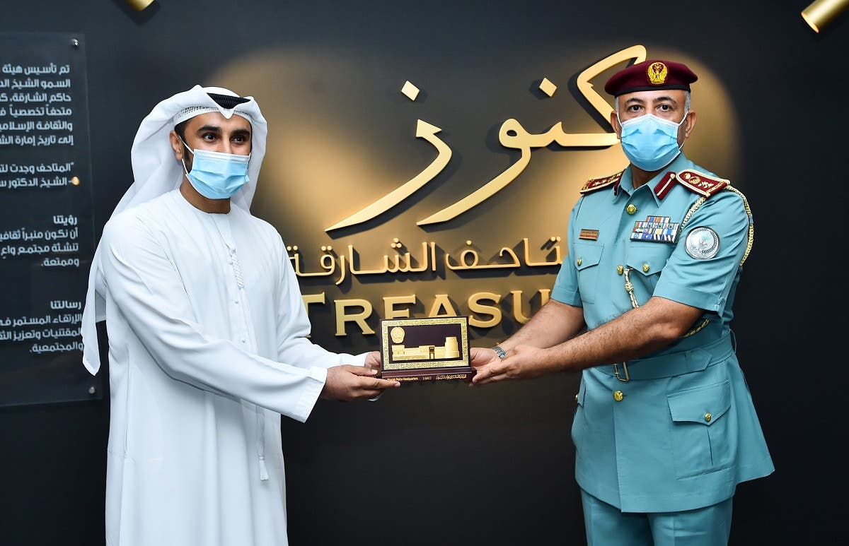 Nasir Al Darmaki. Museums Strategic Planning Department Manager - SMA, exchanges a memento with an official of the Sharjah Police. (Courtesy: SMA)