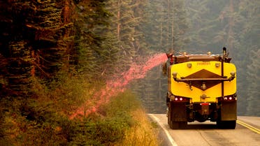 A truck sprays fire retardant on vegetation to help stop the spread of the North Complex Fire in Plumas National Forest, Calif., on Monday, Sept. 14, 2020. (AP Photo/Noah Berger)