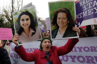 A woman holds images of imprisoned pro-Kurdish lawmakers Figen Yuksekdag, left, who was charged with insulting the president, and Selma Irmak in Ankara. (File photo: AP)