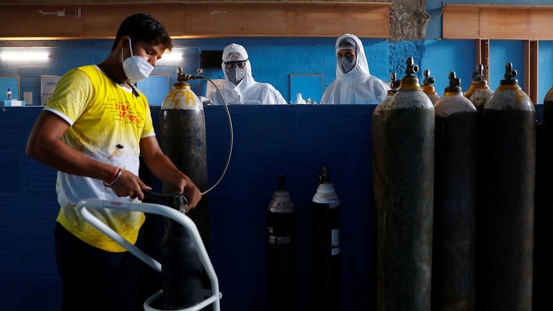 A worker refills an oxygen cylinder as medical workers wait at the Yatharth Hospital in Noida, on the outskirts of New Delhi, India, on September 15, 2020. (Reuters)