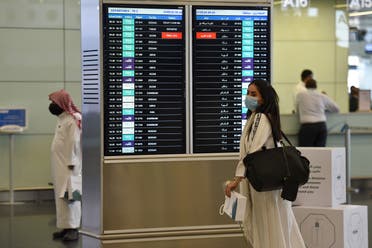 A Saudi passenger, wearing a protective face mask, arrives at terminal 5 in the King Fahad International Airport. (AFP)