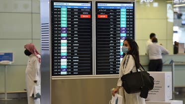 A Saudi passenger, wearing a protective face mask, arrives at terminal 5 in the King Fahad International Airport. (AFP)