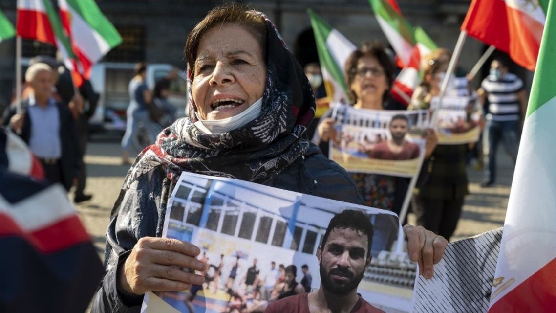 A woman holds a portrait of Iranian wrestler Navid Afkari during a demonstration on the Dam Square in Amsterdam, against his execution in the southern Iranian city of Shiraz and against the Iranian government, September 13, 2020. (AFP)
