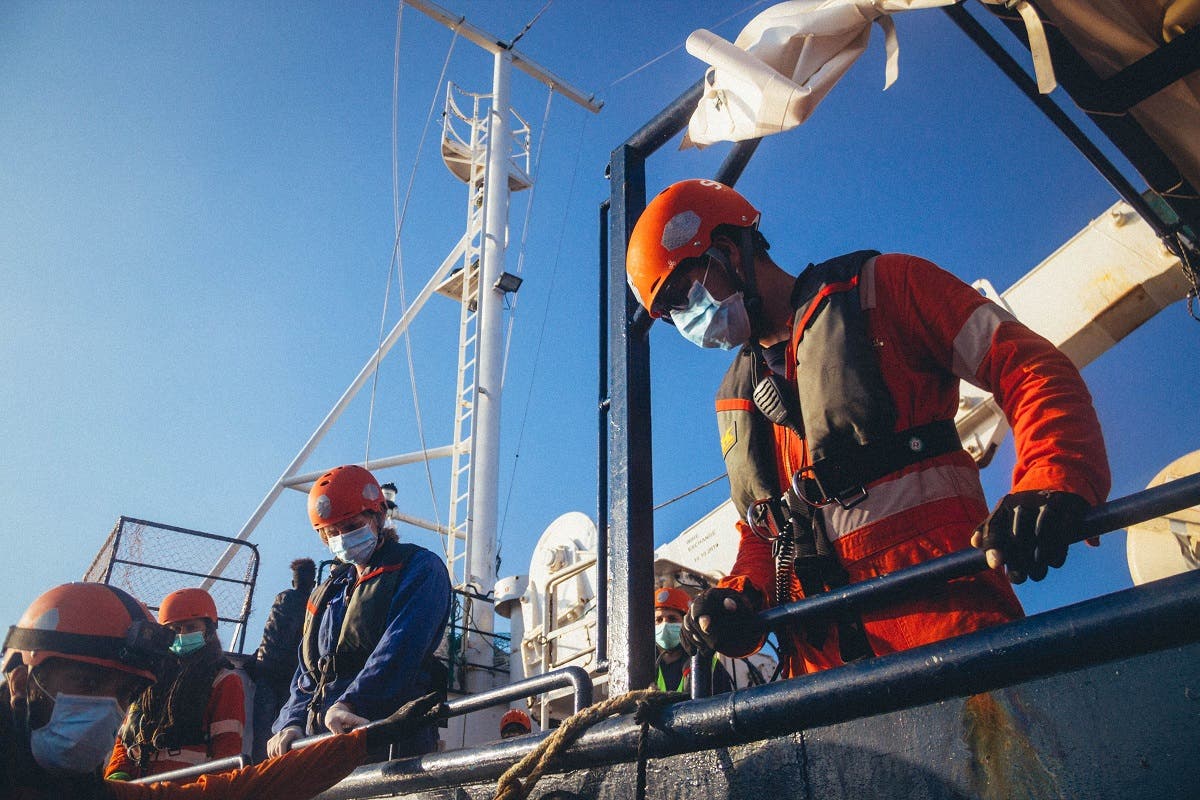 A handout picture released by German migrant rescue NGO Sea-Eye and taken on April 6, 2020, shows members of the NGO on board their vessel Alan Kurdi during a rescue operation off the Libyan coast. (AFP)