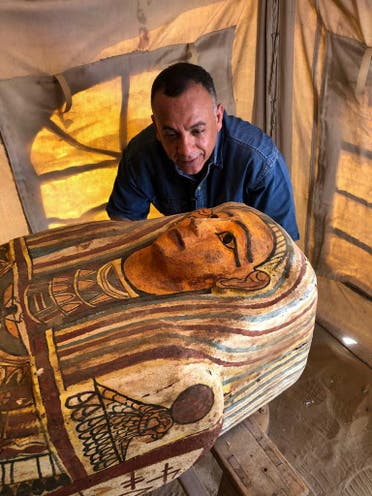 A handout picture released by Egypt’s Ministry of Antiquities on September 20, 2020, shows Secretary General of the Supreme Council of Antiquities Mostafa Waziri (C) inspecting one of fourteen coffins discovered in Saqqara. (AFP)