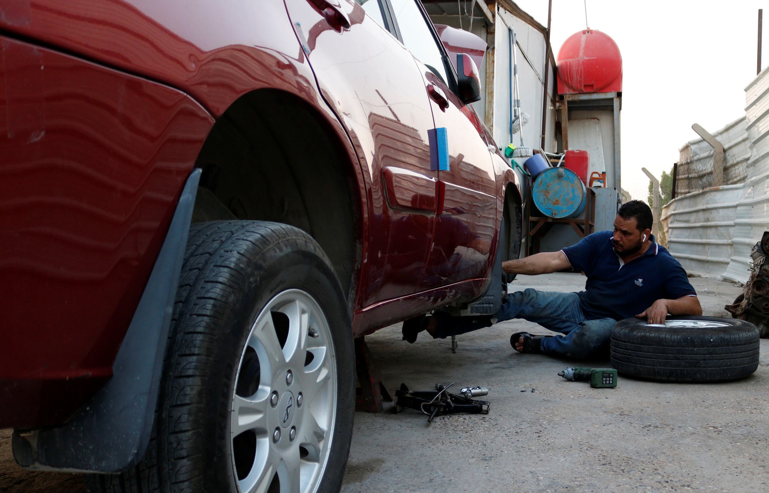 Mustafa Aziz, an Iraqi blind mechanic, repairs a customer car at a garage in Baghdad, Iraq September 6, 2020. Picture taken September 6, 2020. (Reuters)
