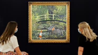 Visitors sit in front of painting by the artist Banksy’s titled “Show me the Monet” at Sotheby’s in London, Britain, on September 18, 2020. (Reuters)