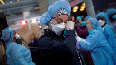 A nurse wipes away tears as she stands outside NYU Langone Medical Center on 1st Avenue in Manhattan as New York police came to cheer and thank healthcare workers in New York City, New York, US. (File photo: Reuters)