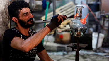 A glassblower forms glass at factory, which is recycling the broken glass as a result of the Beirut explosion, in the northern Lebanese port city of Tripoli on August 25, 2020. (AFP)