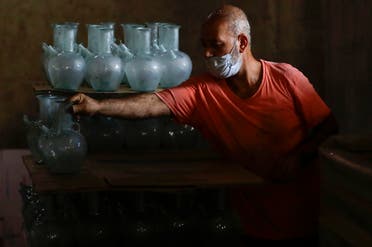 A worker arranges finished jugs at a factory, which is recycling the broken glass as a result of the Beirut explosion, in the northern Lebanese port city of Tripoli on August 25, 2020. (AFP)