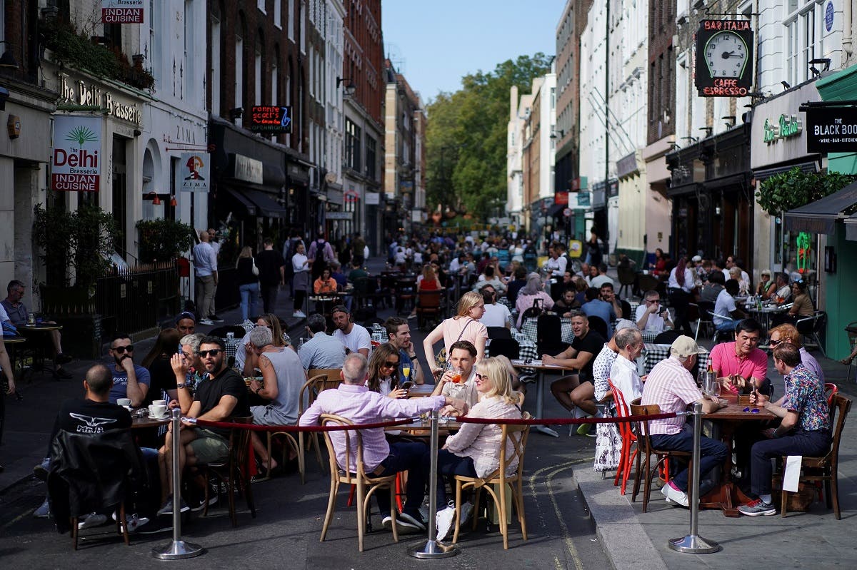 People sit at the tables outside restaurants in Soho, amid the coronavirus disease (COVID-19) outbreak, in London, Britain. (Reuters)