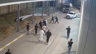 A screengrab from a Reuters video shows relatives of covid-19 victim approaching Iraqi doctor and head of the al-Amal hospital, Tarik al-Sheibani, in the hospital parking lot and attacking him. (Reuters)