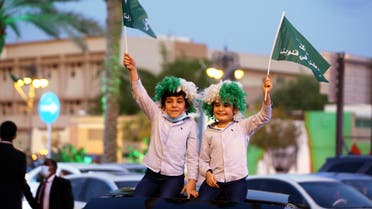 Children wave flags as people celebrate Saudi Arabia's 90th annual National Day, amid the spread of the coronavirus disease (COVID-19) in Riyadh, Saudi Arabia September 23, 2020. (Reuters)