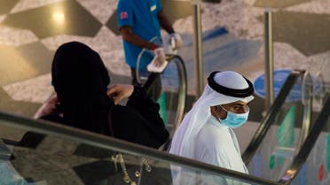An Emirati man and woman ride an escalator at Mall of the Emirates in Dubai. (File photo: AP)