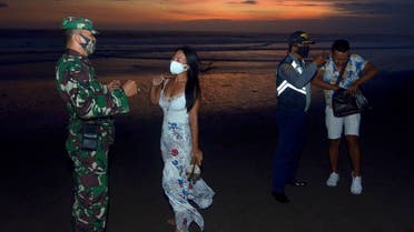 Officers wearing protective face masks give warning to visitors for wearing protective masks, amid the coronavirus disease (COVID-19) outbreak in Badung, Bali Province, Indonesia, on September 3, 2020. (Reuters) _1719615014_RC22UI9DONXJ_RTRMADP_3_HEALTH-CORONAVIRUS-INDONESIA-BALI