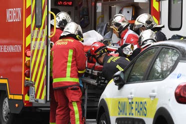 French firefighters load an injured person into a waiting ambulance near the former offices of the French satirical magazine Charlie Hebdo. (AFP)