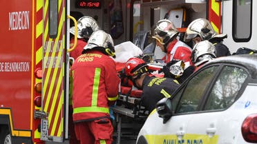 French firefighters load an injured person into a waiting ambulance near the former offices of the French satirical magazine Charlie Hebdo. (AFP)