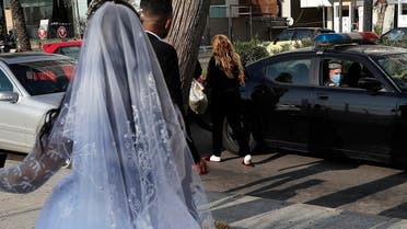 A policeman asks a bride and groom to leave the waterfront promenade where they had decided to take some pictures, in Beirut, Lebanon. (File Photo: AP)
