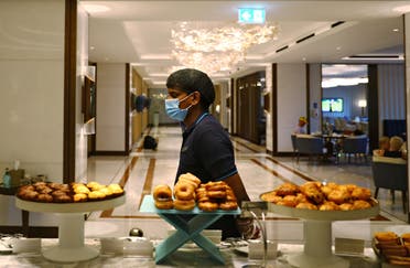 A waiter wearing a face mask walks past a buffet in the Atlantis The Palm hotel in Dubai. (File photo: Reuters)
