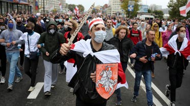 Demonstrators, one of them wearing an old Belarusian nation flag and holding a cardboard sword reading solidarity march during an opposition rally to protest the official presidential election results in Minsk, Belarus, Sunday, Sept. 27, 2020. (AP)
