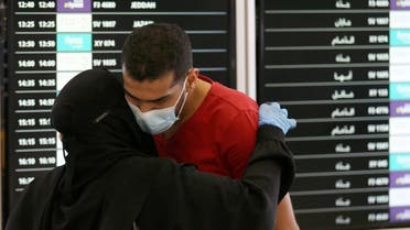 A man wearing a protective mask kisses his wife before she travels at Riyadh International Airport. (Reuters)