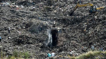Rescue workers conduct a search operation on the Pirana landfill after Neha Vasava, 12, got buried under a mass of trash that fell while she was collecting discarded toys on the garbage mountain with her friend Anil Marwadi, 6, who got rescued, on the outskirts of Ahmedabad on September 27, 2020. (AFP)
