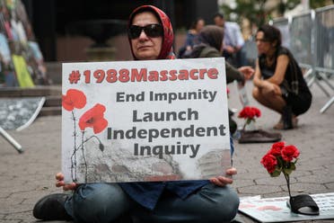 A woman holds a poster that reads 1988 Massacre. End Impunity Launch Independent Inquiry as she attends a protest against Iranian President Hassan Rouhani outside of U.N. headquarters. (Reuters)