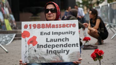 A woman holds a poster that reads 1988 Massacre. End Impunity Launch Independent Inquiry as she attends a protest against Iranian President Hassan Rouhani outside of U.N. headquarters. (Reuters)