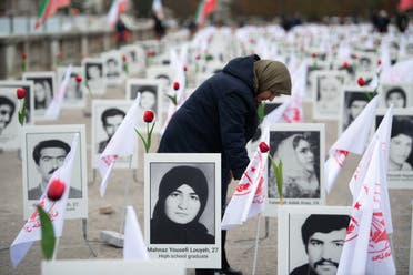 A member of the People's Mujahedin of Iran in France displays portraits of victims on the Esplanade des Invalides in Paris on October 29, 2019 to commemorate the executions of thousands of Iranian political prisoners in 1988. (AFP)