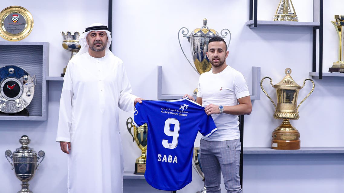 Israeli midfielder Dia Saba (R) posing with a club official during his official presentation at the al-Nasr club. (Reuters)