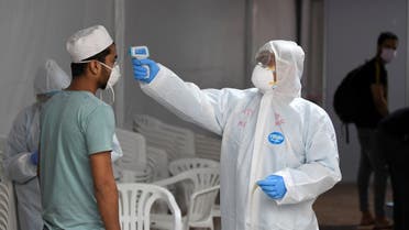 A foreign worker gets his body temperature tested for the novel coronavirus at a testing centre in the Naif area of the Gulf Emirate of Dubai, on April 15, 2020. (AFP)