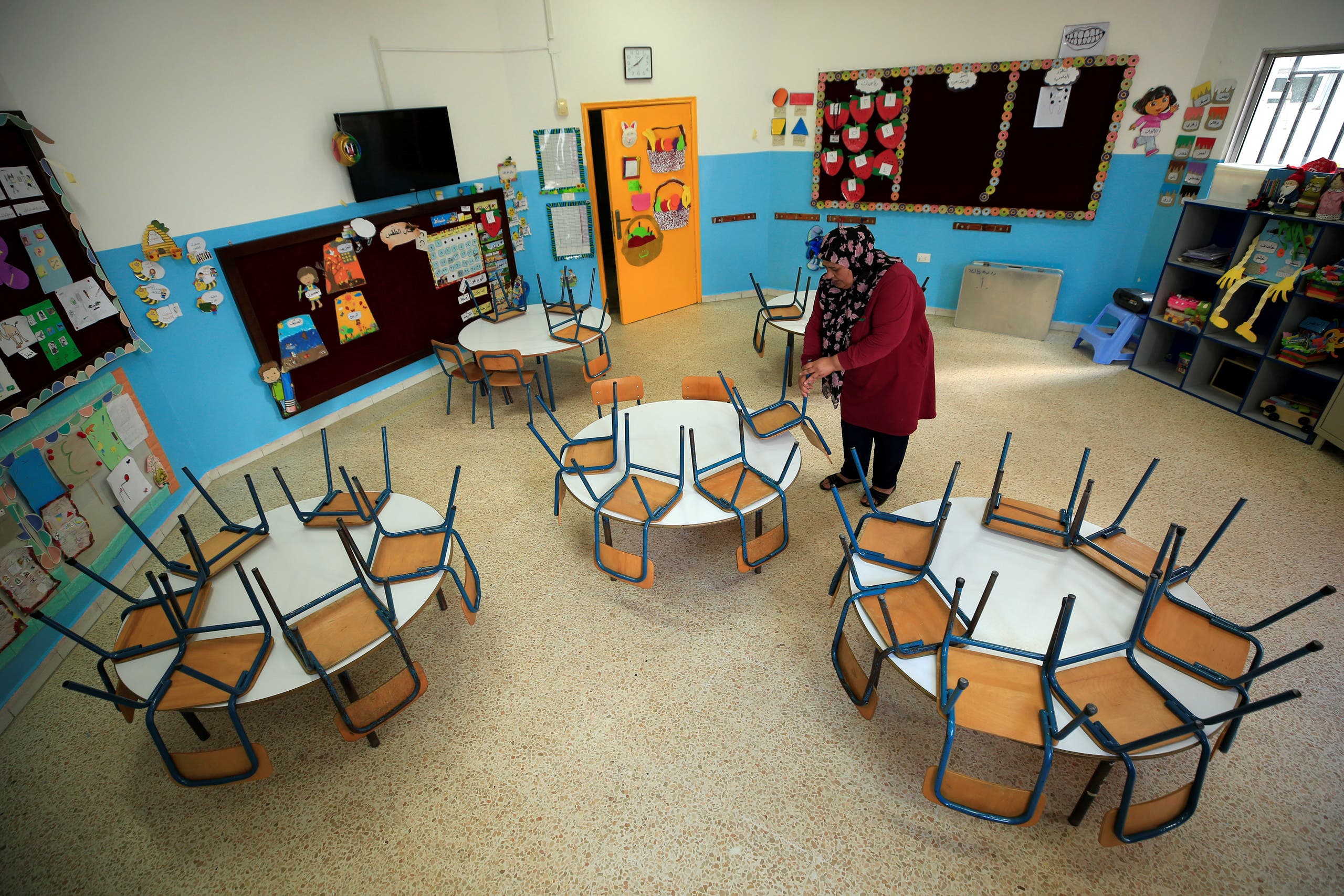 A worker cleans an empty classroom at a school, as Lebanon's education system is in limbo with multiple challenges, in Sidon Lebanon, May 29, 2020. (Reuters)