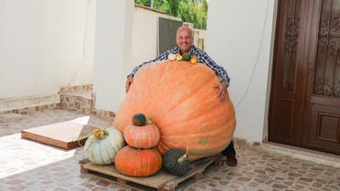 Abdul Salam Mohammad al-Mughrabi hugs his 341-kg. pumpkin that he grew at his home in Lebanon; he says the pumpkin is the largest in the Middle East. (Moe Shamseddine)