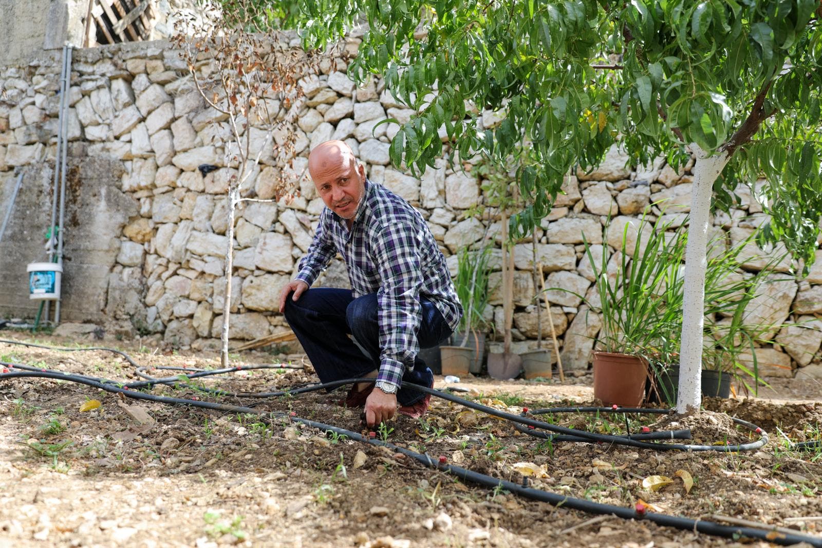 Abdul Salam Mohammad al-Mughrabi points to his irrigation system used to water his pumpkins. (Moe Shamseddine)