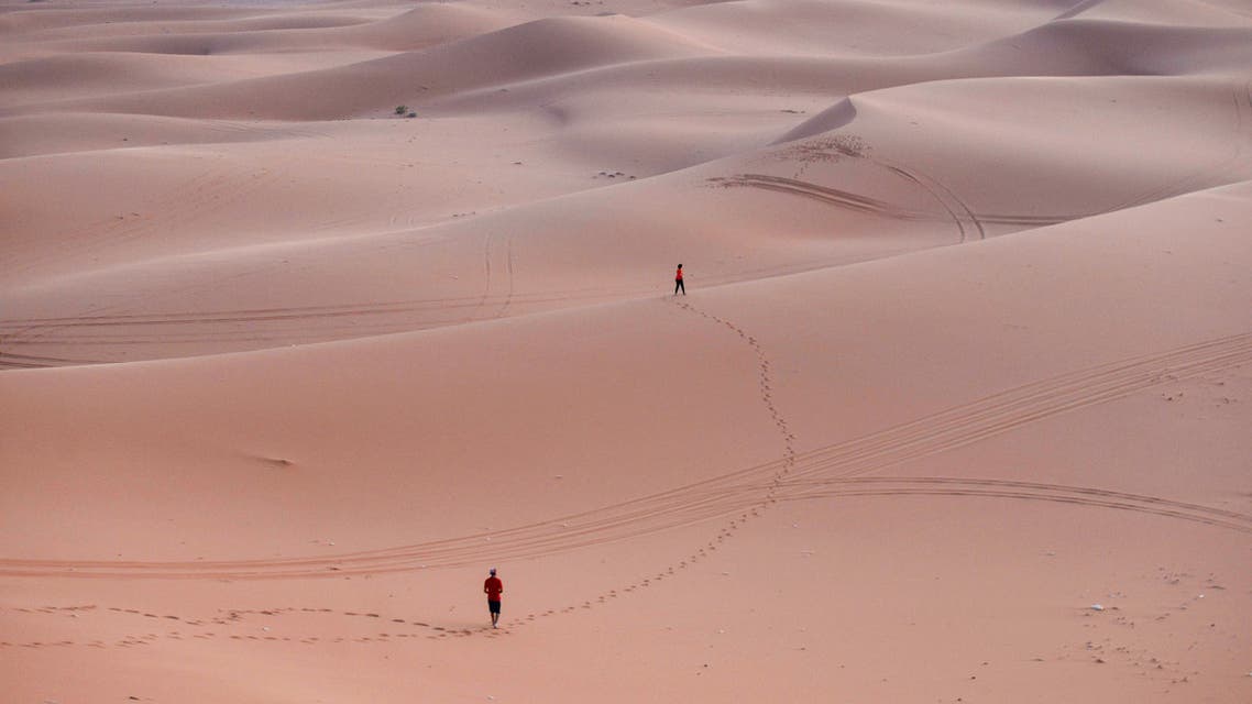 Tourists walk on the sand after surfing in the Saed desert area, 110 kilometers east of Riyadh City, on August 29, 2020. (AFP)