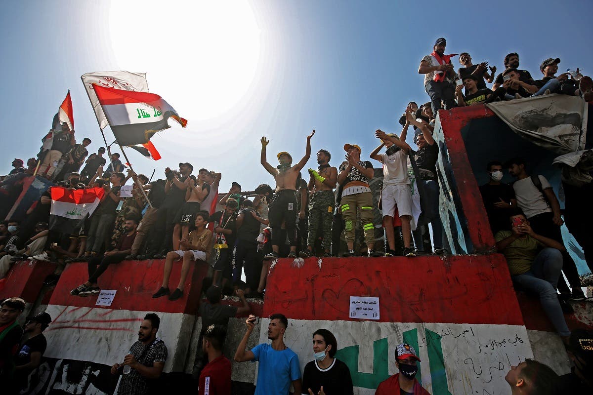 Iraqi protesters chant slogans and wave the national flag during a demonstration in Tahrir Square in the center of Iraq's capital Baghdad on Oct. 1, 2020. (AFP)