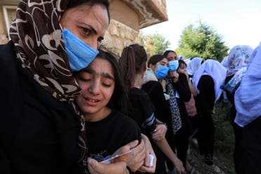 An Iraqi Yazidi woman comforts a grieving youngster during the funeral of Baba Sheikh Khurto Hajji Ismail (image), supreme spiritual leader of the Yazidi religious minority. (AFP)